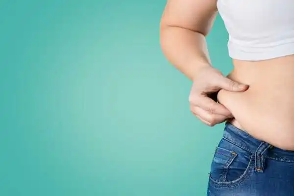 Image of woman pinching her love handles to show weight gain Atherstone